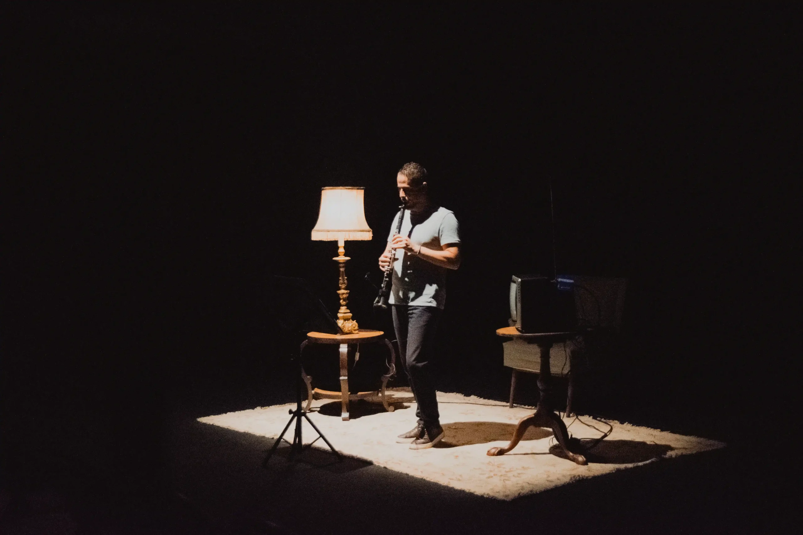 Cena do espetáculo Elíptico, com candeeiro e cenário teatral em palco