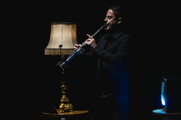 Ruben Jacinto a tocar clarinete junto a um candeeiro dourado