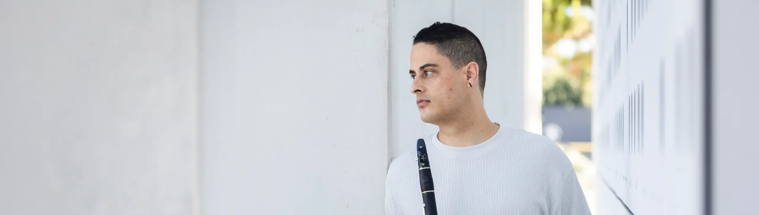 Retrato de Ruben Jacinto com o clarinete, encostado a uma parede clara